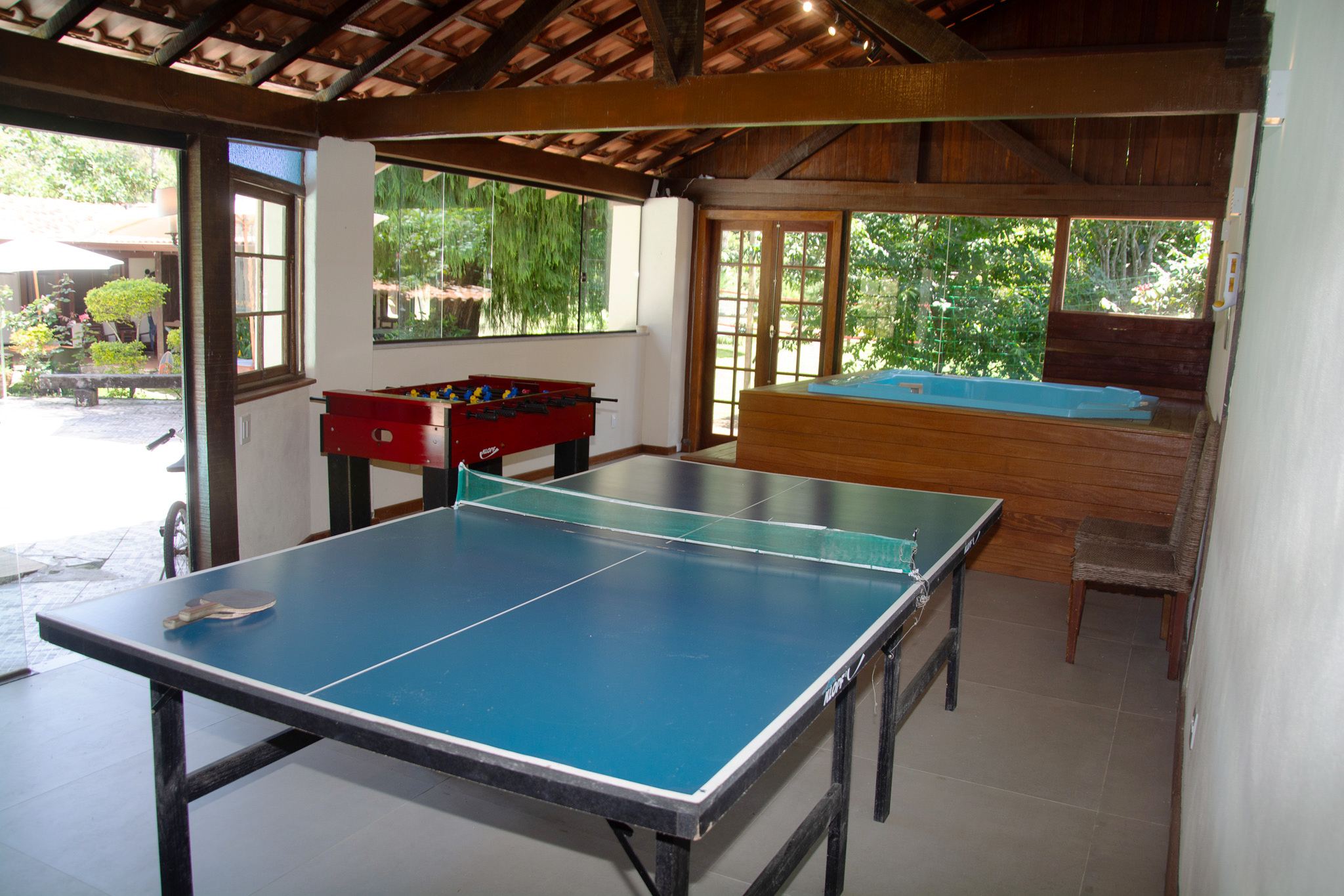 Salão de jogos com mesa de pingue-pongue e pebolim